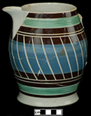 Pitcher with green-glazed rilling or reeding at top and bottom and engine-turned pattern.
